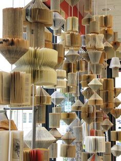 a room filled with lots of books hanging from the ceiling