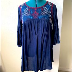 Long Tunic Blouse. Navy Blue With Embroidery Along Neckline. Bell Sleeves. 30” Long Blue Folk Top With Geometric Embroidery, Blue Blouse With Geometric Embroidery For Spring, Spring Blue Blouse With Intricate Embroidery, Spring Blue Geometric Embroidered Blouse, Blue Blouse With Intricate Embroidery For Spring, Embroidered Long Sleeve Blue Tunic, Long Sleeve Embroidered Blue Tunic, Blue Folk Style Blouse For Spring, Bohemian Blue Embroidered Top With Geometric Patterns