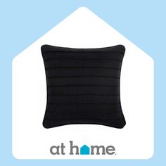 a black pillow sitting on top of a blue and white house with the words at home above it