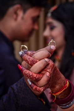 the bride and groom are holding their wedding rings