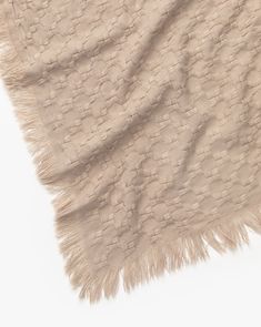 a beige blanket with fringes on it