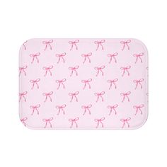 a pink bath mat with pink bows on the front and back of it, all over