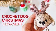 a crochet dog christmas ornament is being held by someone's hand