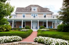 a large house with white flowers in the front yard