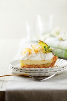 a piece of pie with whipped cream and fruit on top sits on a white plate