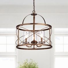 a chandelier hanging from the ceiling in a dining room with potted plants