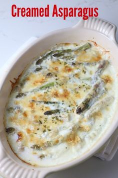 a casserole dish with cheese and asparagus in it on a white plate