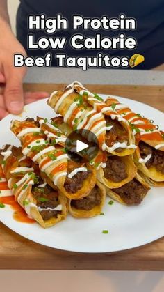 a white plate topped with beef taquitass covered in sauce