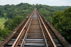 an overhead view of train tracks with trees in the background