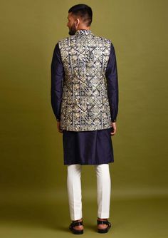 Editor's Note Navy Blue Open Bundi Jacket In Silk Base With Thread And Patra Embroidery. It Is Paired With A Matching Kurta And Pyjama Pants. Color: Navy Blue Fabric: Silk Care: Dry Clean Only About the Designer Inspired By The Minimalism, Utilitarianism And Functionality, Chatenya Mittal Is A Label Focused Entirely On Menswear. Chatenya Mittal Is Revisiting The Classic Silhouette Bringing New Energy And Working To Create Future Classics By Subtly Combining Fabric Blocking, Layering, Attention T Fitted Blue Outerwear With Chikankari Embroidery, Festive Blue Nehru Jacket With Floral Embroidery, Blue Traditional Wear For Winter Festivals, Blue Traditional Wear For Festive Winter Occasions, Blue Long Sleeve Set With Gold Embroidery, Winter Festive Blue Traditional Wear, Traditional Blue Floral Embroidered Outerwear, Blue Floral Embroidered Outerwear For Wedding, Festive Blue Outerwear With Resham Embroidery