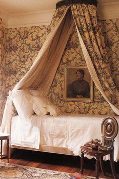 a bed in a bedroom with a canopy over it's headboard and foot board