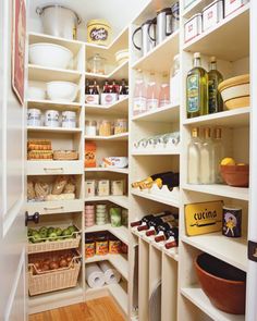 an organized pantry with white shelving and lots of food on the shelves, along with baskets