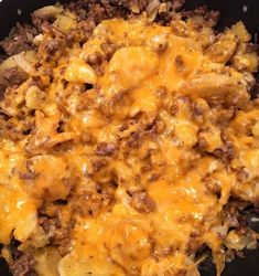 a skillet filled with meat and cheese covered in melted cheese on top of it