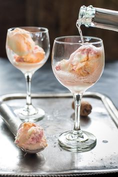 two glasses filled with ice cream sitting on top of a metal tray