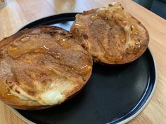 two baked goods are sitting on a black plate