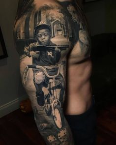 a man with a tattoo on his arm has a photo of a boy riding a bike