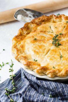 a pie sitting on top of a white plate next to a spatula and wooden spoon