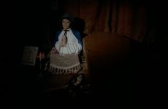 a doll is sitting on a chair in the dark