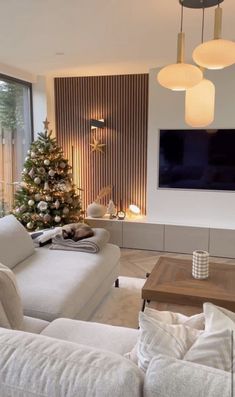 a living room filled with furniture and a christmas tree in front of a flat screen tv