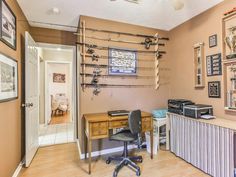 a home office with lots of clutter on the desk and shelves in front of it