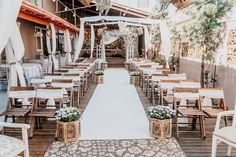 an outdoor wedding venue with white linens and wooden chairs