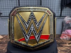 a gold and red wrestling belt sitting on top of a table