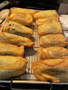 several pastries are lined up on a cooling rack in the oven, ready to be baked