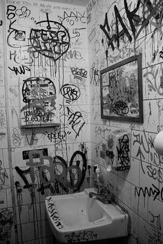 a bathroom with graffiti all over the walls