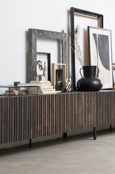 a wooden sideboard with books and pictures on it