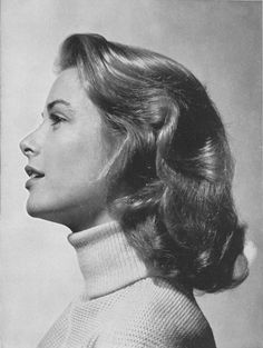 an old black and white photo of a woman with her hair in a high bun