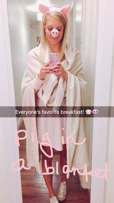 a woman in pig ears is taking a selfie with her cell phone while wearing a white robe