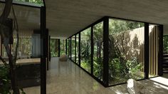 the interior of a house with large glass walls and trees in the backround