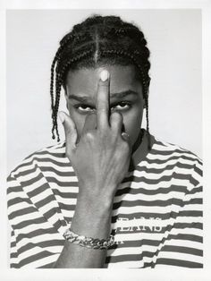 a black and white photo of a woman holding her hand to her face with both hands