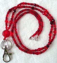 Red Beaded Lanyard This Red Beaded Lanyard can be used as a badge holder, an I.D. holder, keychain necklace, watch holder - it's a multi-use accessory for home or office! 34" in length, long enough to put on or remove overhead. It also has an easy-to-use metal lobster clasp for your convenience. It's made with red glass beads and strung on strong C-Lon beading cord. Snap-on badge holder, clip, and keyring are included to keep your badges or keys ready when you need them. This Red Beaded Lanyard Keychain Necklace, Beading Cord, Beaded Lanyard, Watch Holder, Beaded Lanyards, Id Badge Holders, Red Bead, Badge Holder, Id Badge