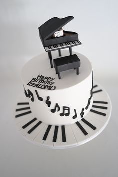 a cake decorated with piano keys and musical notes on it's side, as well as the words happy birthday