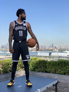 a man holding a basketball standing on top of a platform