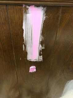 the paint is pink and white on the wooden door