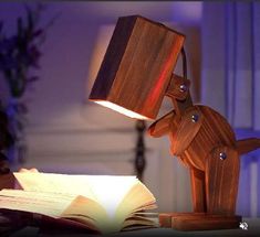 a wooden dog lamp sitting on top of an open book