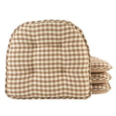 the brown and white checkered chair cushion is folded on top of two other pillows