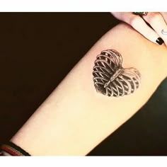 a woman's arm with a pine cone tattoo on it