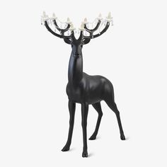 a black deer statue with four lights on it's antlers