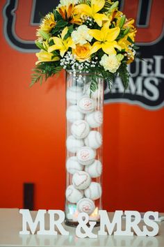 a vase filled with lots of white and yellow flowers next to a sign that says mr & mrs