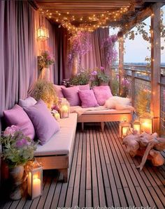 an outdoor deck with lots of lights and pillows on it, surrounded by plants and candles