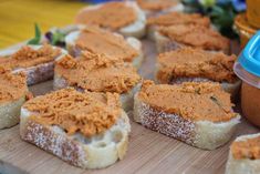 several pieces of bread with peanut butter on them sitting on a cutting board next to a container