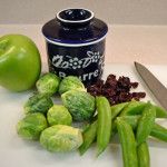 some vegetables are on a cutting board next to a knife and an empty bottle with the lid