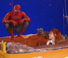 a woman in a fake spiderman suit sitting next to a man with red hair