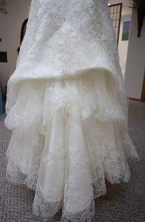 a white wedding dress is on display in a room with carpeted floor and walls