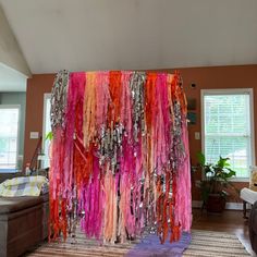 there are many different colored streamers hanging from the ceiling in this living room area