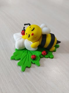 a yellow and black bee sitting on top of a green leafy plant with ladybugs