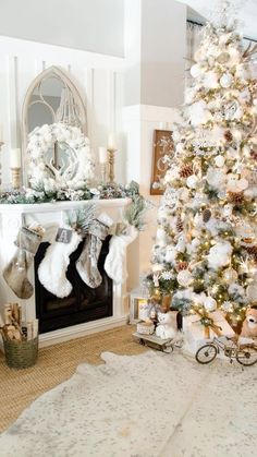 a decorated christmas tree in the corner of a living room with white and silver decorations